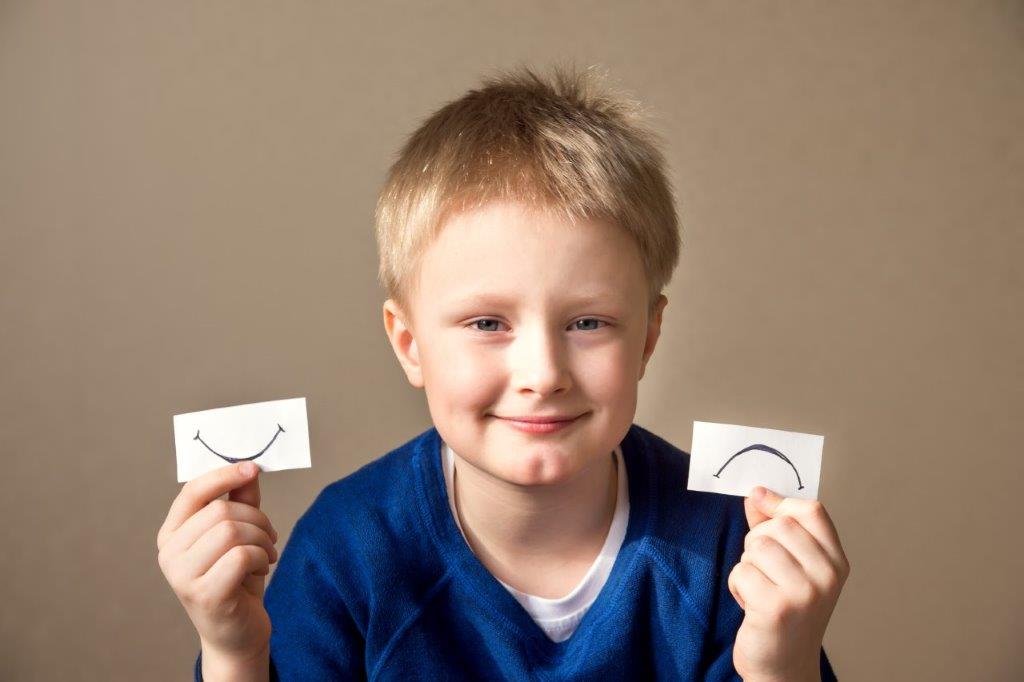 Photo of Boy holding frown and smile cards, Catherine M. Bowers, PLC Law Office